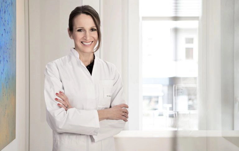 Dr. med. Sonja Diekmann, Kardiologin, lächelnd im weißen Arztkittel in der Praxis am Schlachtensee